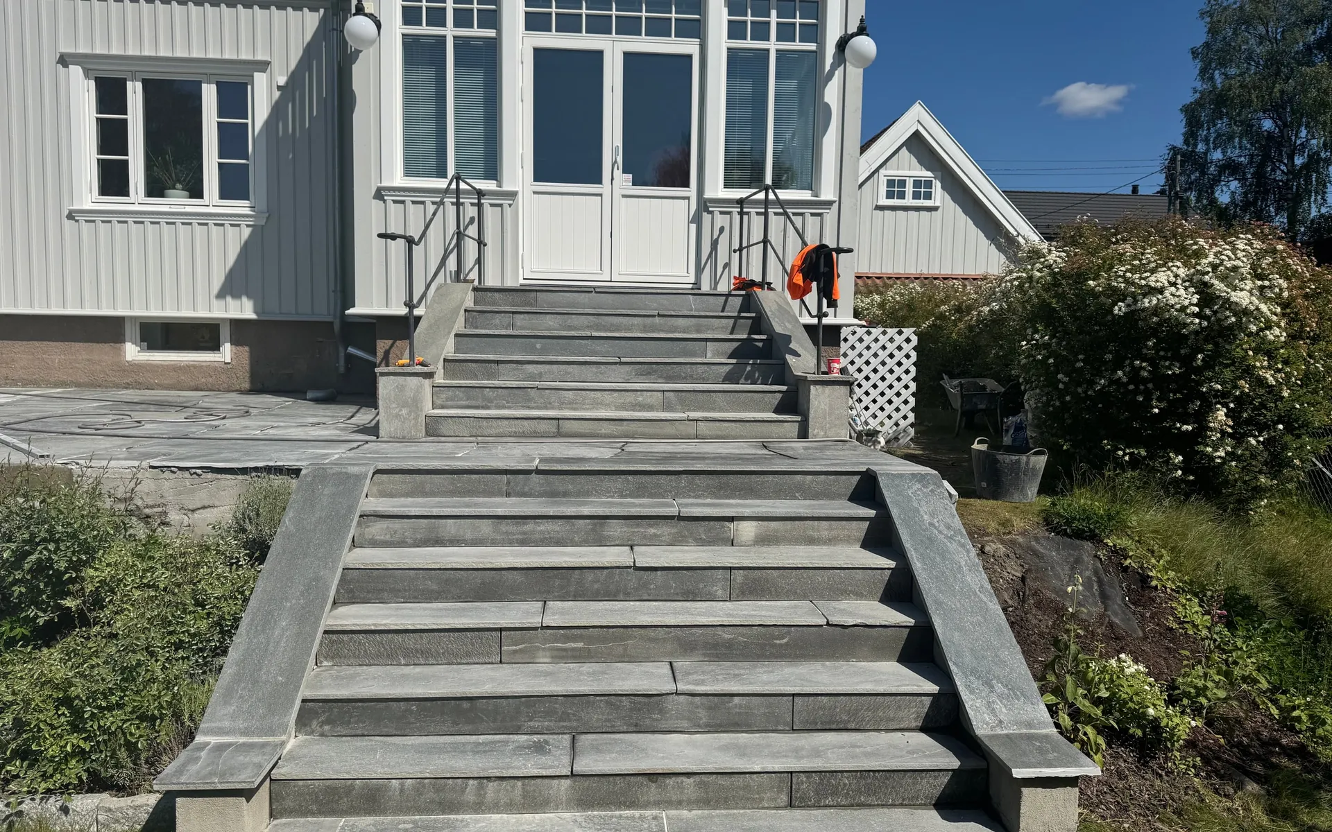 Ny utetrapp i skifer opp til inngangspartiet på en hvit villa i Oslo, bygget av Perfekt Hage