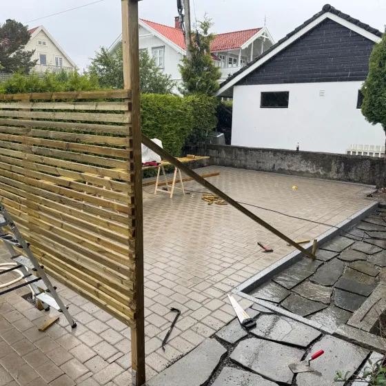 Levegg i liggende spiler reises på nylagt belegningsstein ved skifersone