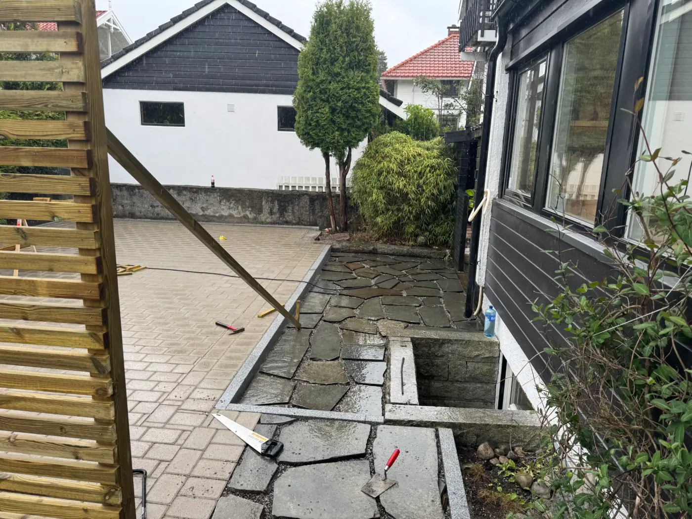 Bruddskifer legges langs husveggen, granittkant mot belegningsstein og lysgrav