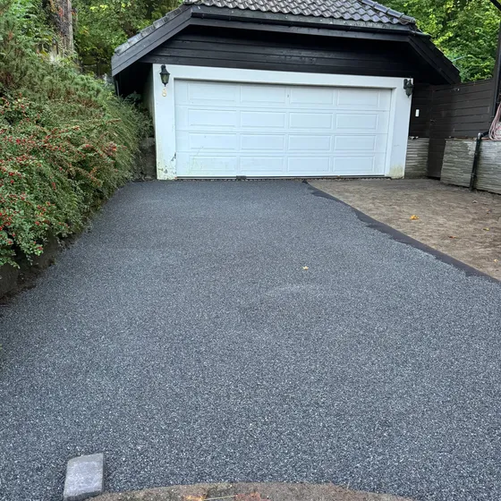 Nyasfaltert oppkjørsel opp mot dobbel garasje