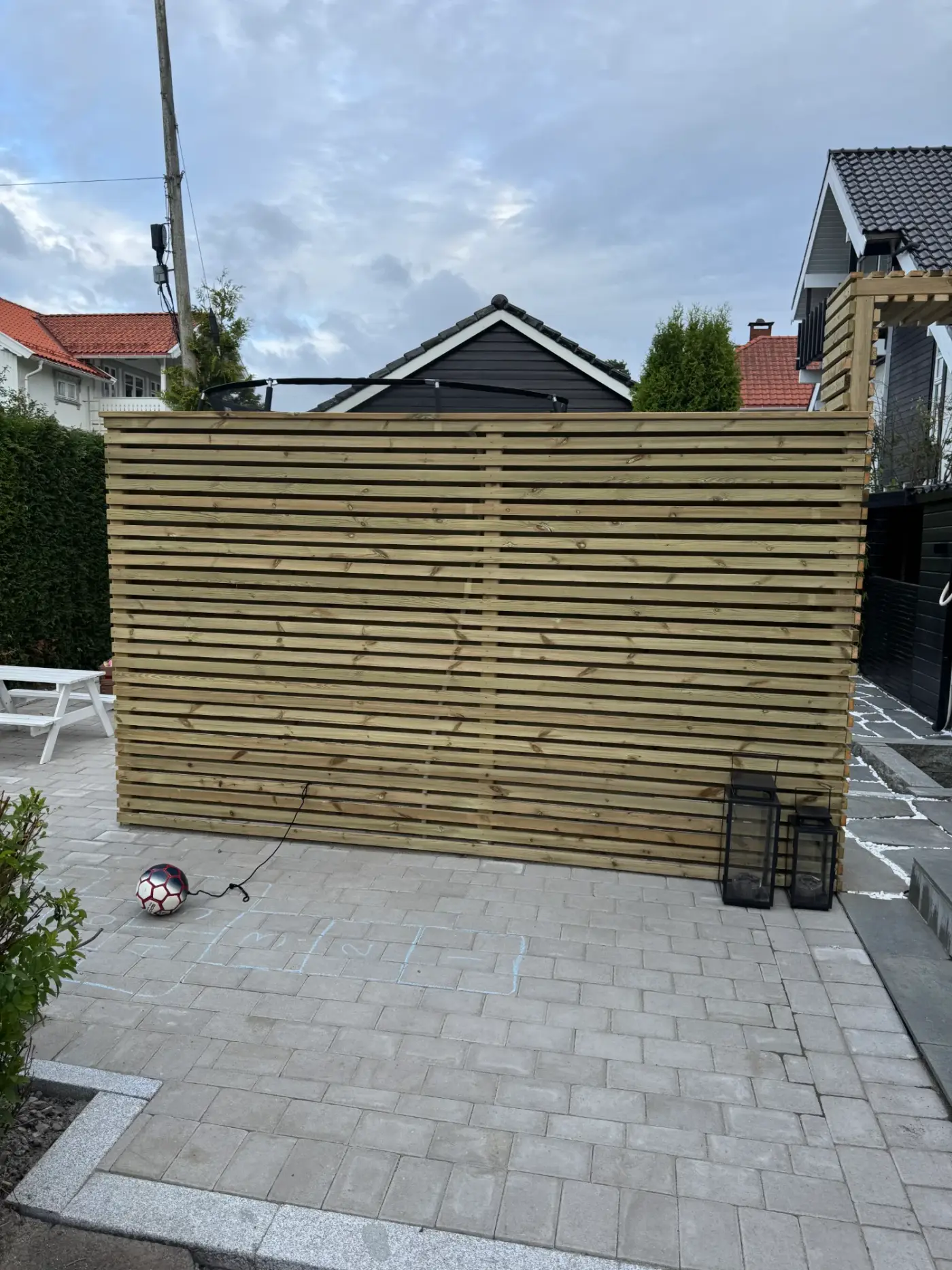 Ferdig levegg i liggende spiler med lykter på lys belegningsstein