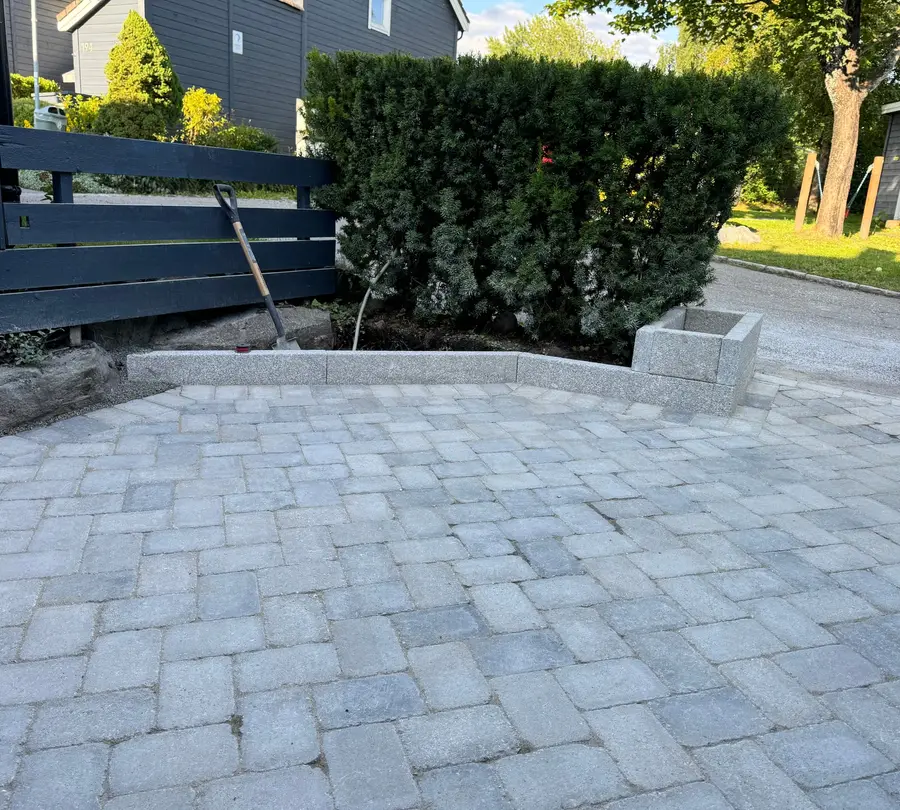 Gårdsplass avgrenset av granitt kantstein og granitt plantekasse
