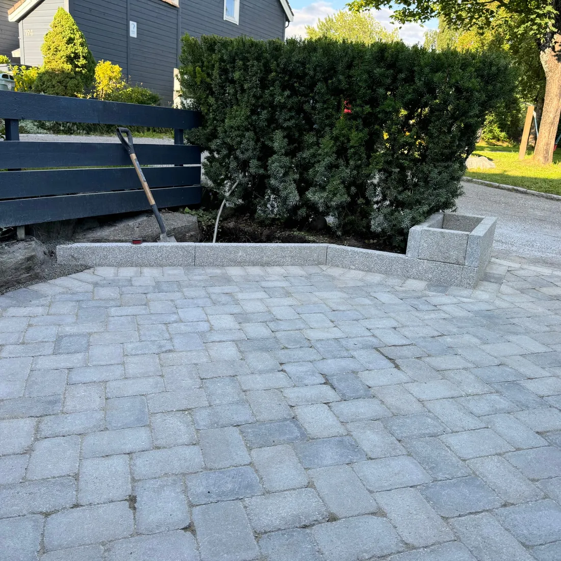 Gårdsplass avgrenset av granitt kantstein og granitt plantekasse