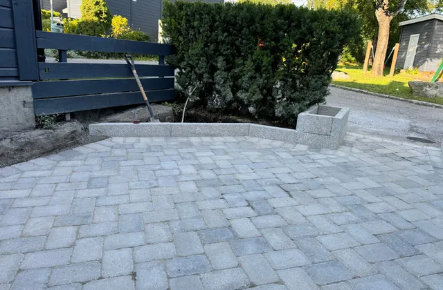 Gårdsplass avgrenset av granitt kantstein og granitt plantekasse