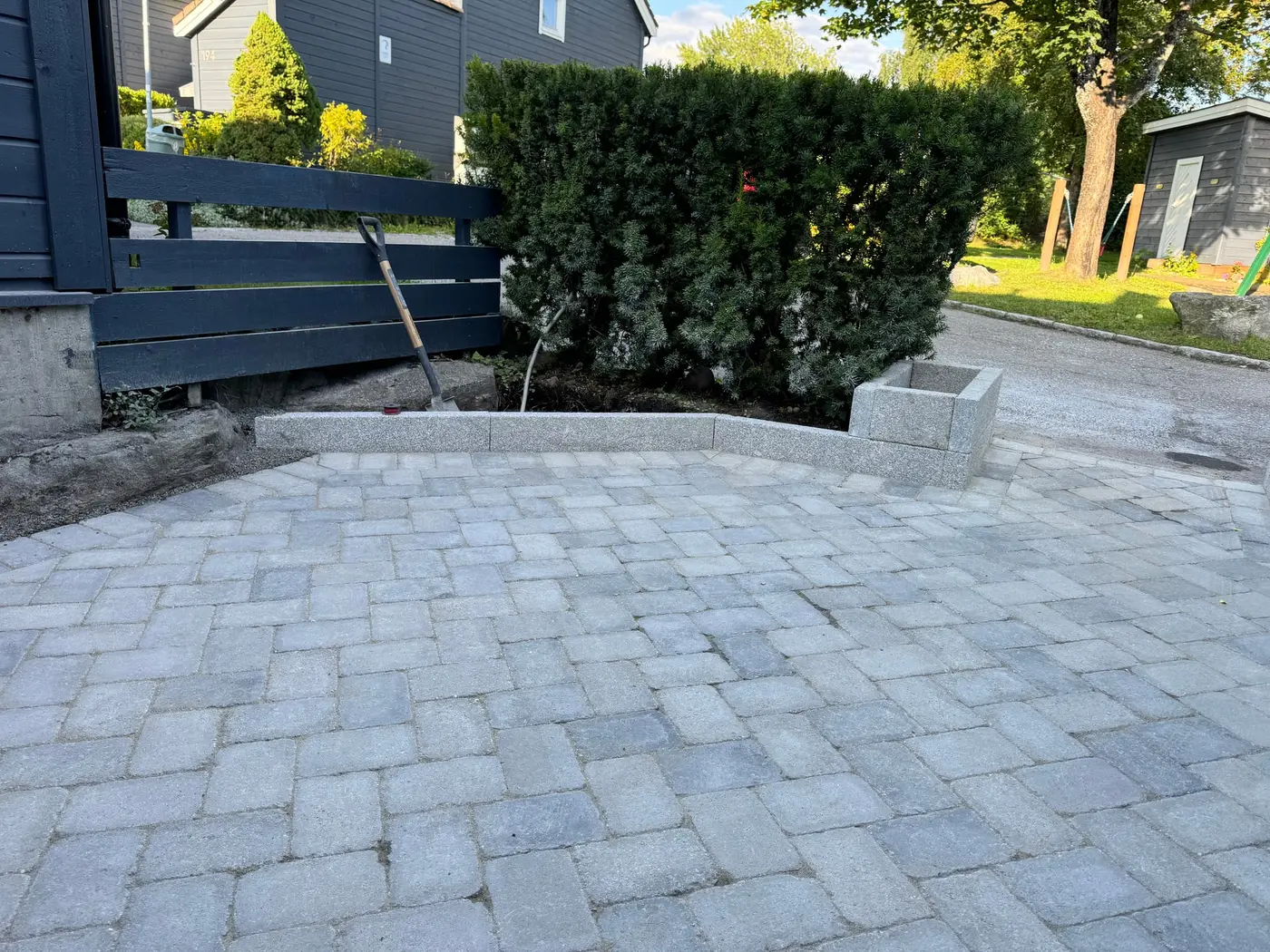Gårdsplass avgrenset av granitt kantstein og granitt plantekasse
