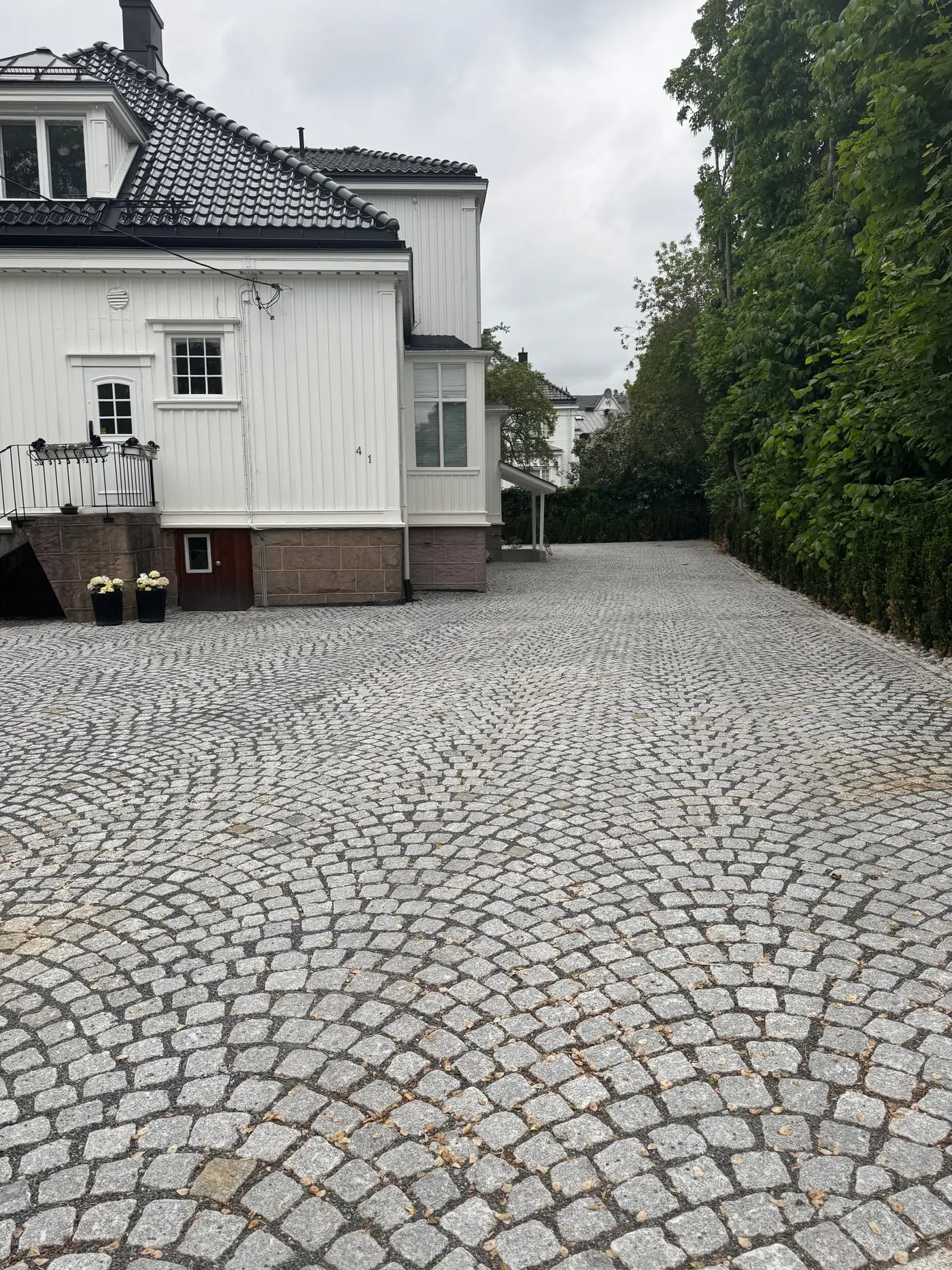 Gårdsplass i granitt smågatestein lagt i buemønster