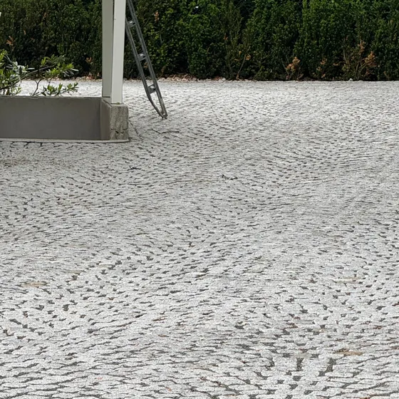 Nærbilde av ferdig brosteinsflate lagt i buemønster