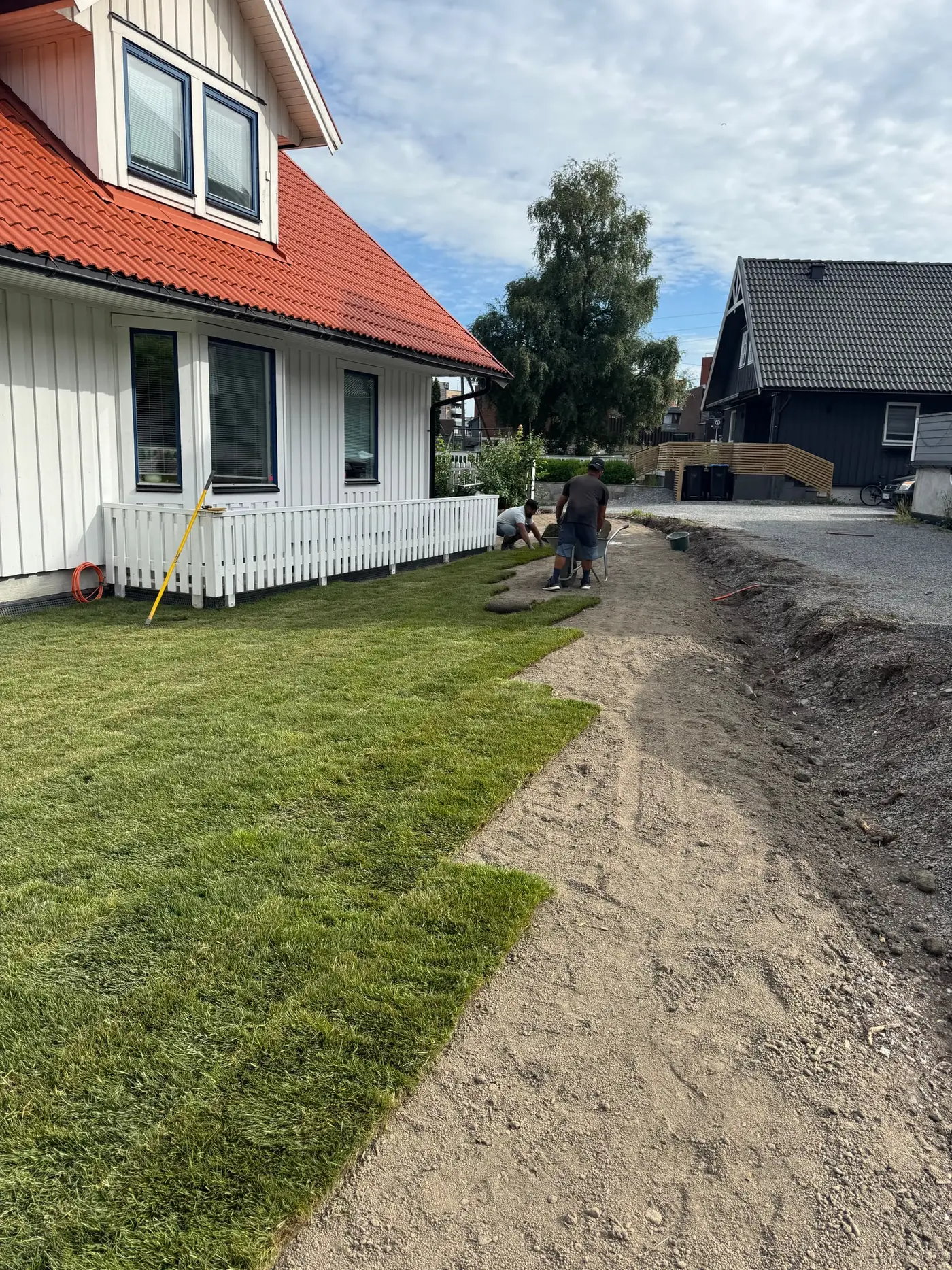 To av våre folk legger ferdigplenruller langs hvitt hus