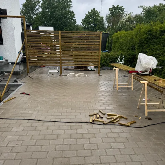 To leveggseksjoner i tre på ferdig lagt belegningsstein under arbeid