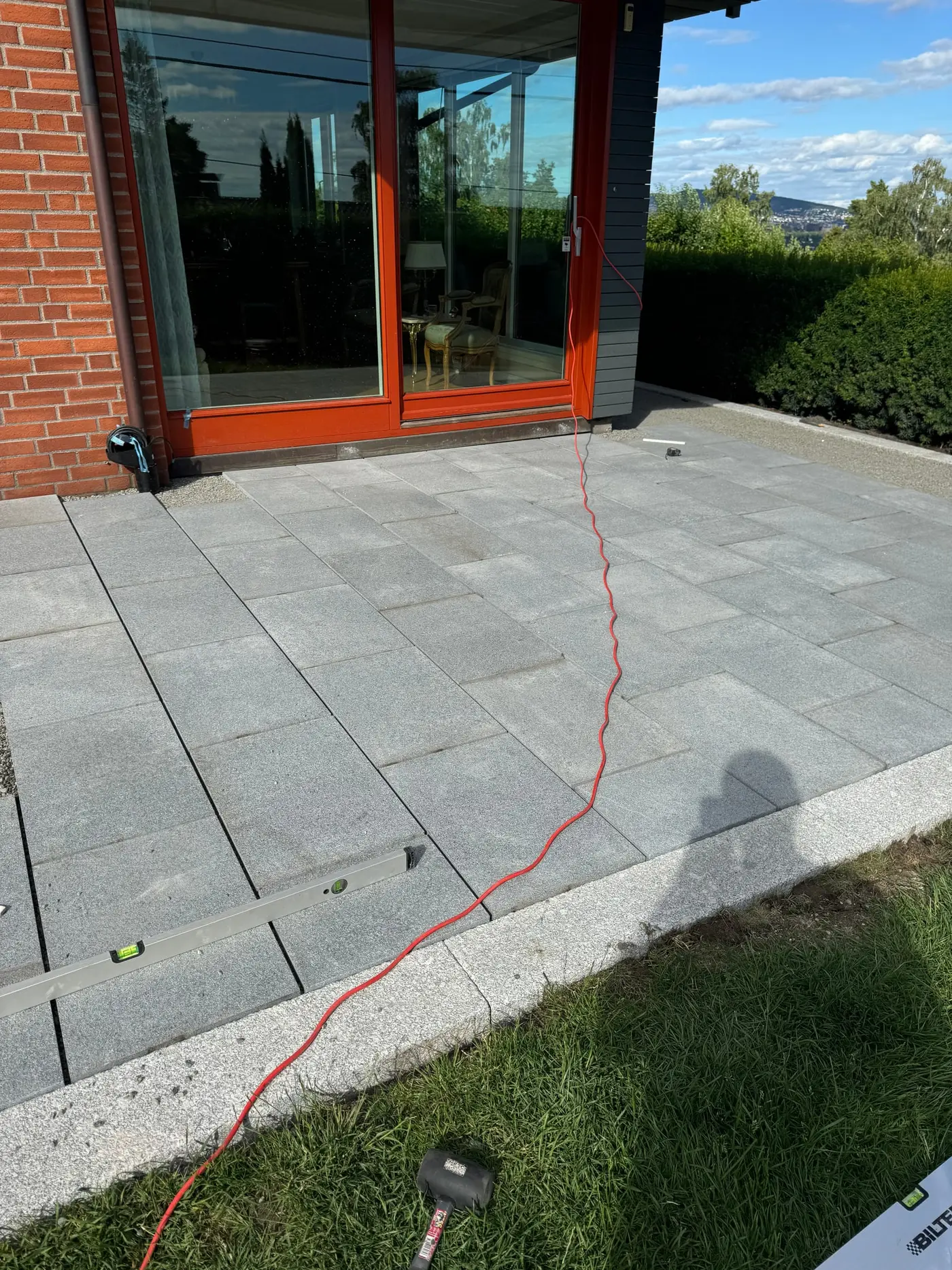 Grå heller legges på uteplass ved terrassedør