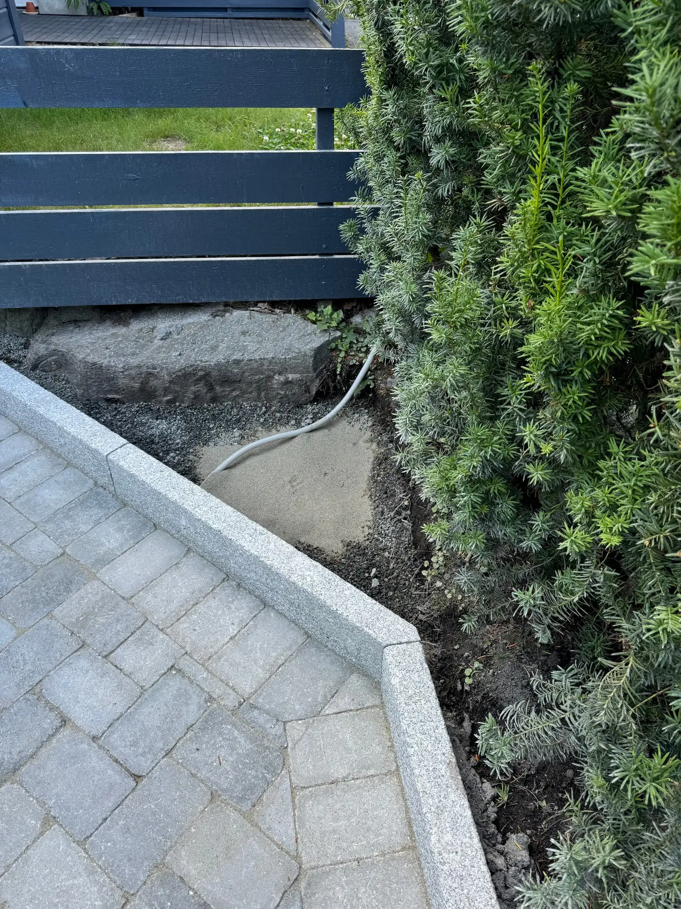 Granitt kantstein langs steinlagt flate under opparbeiding