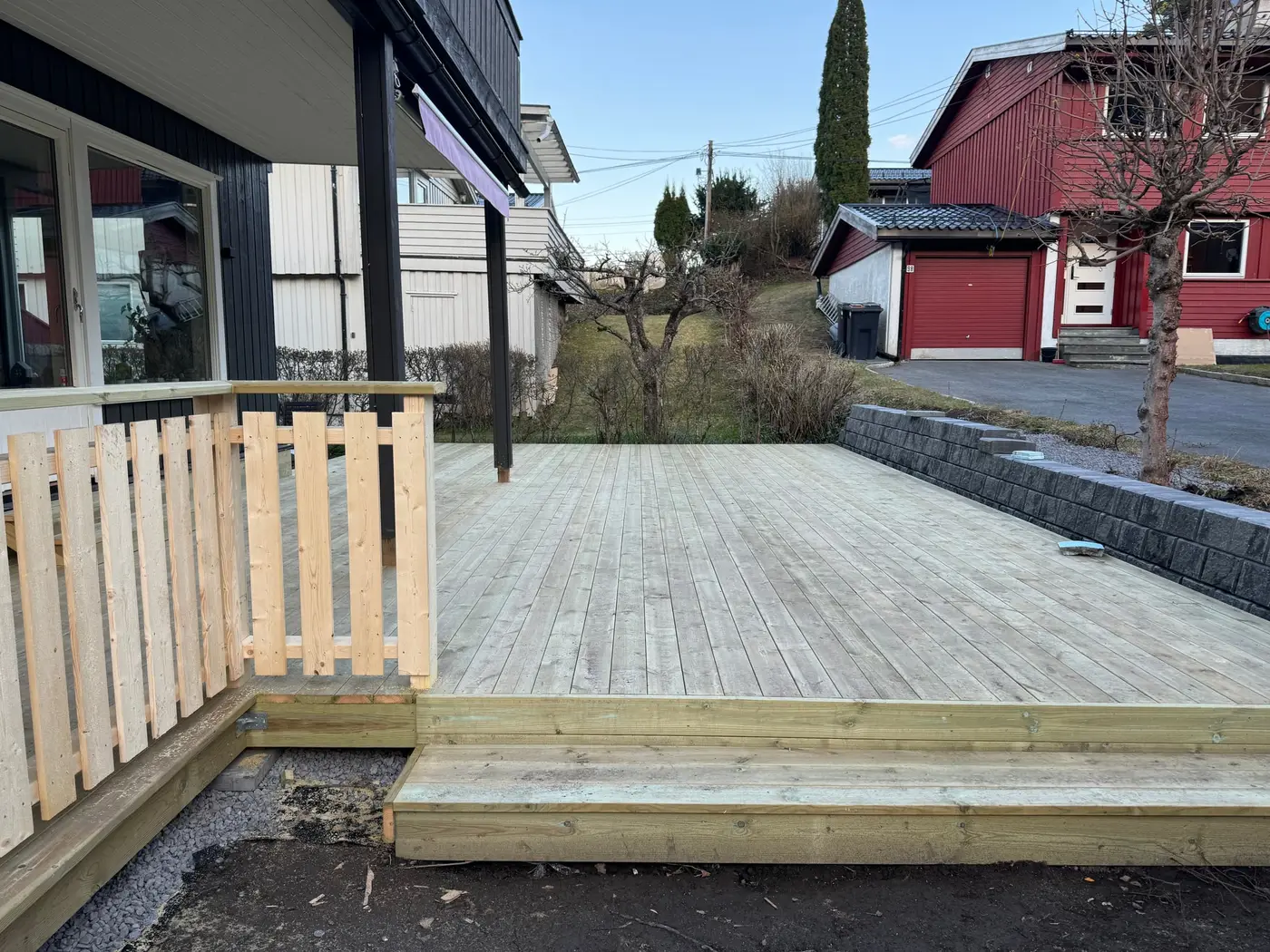 Lav platting i impregnert tre med trinn og betongstøttemur