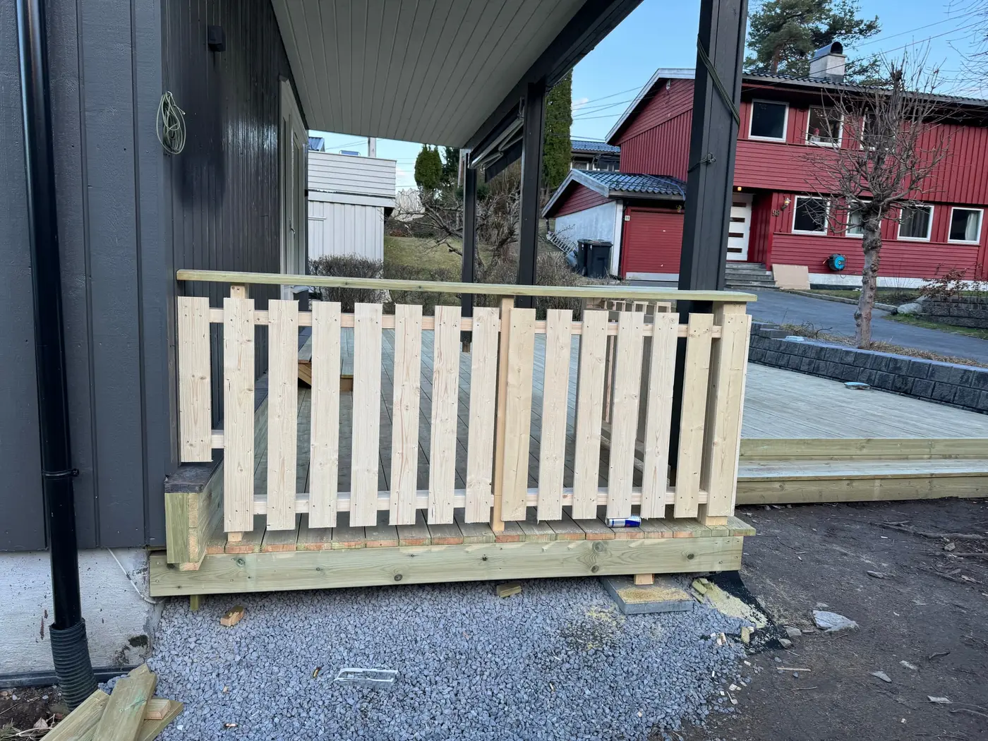 Spilerekkverk i ubehandlet tre langs kanten av ny platting