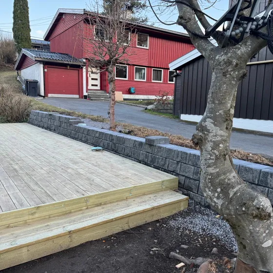 Platting med to trinn ved siden av grå betongstøttemur