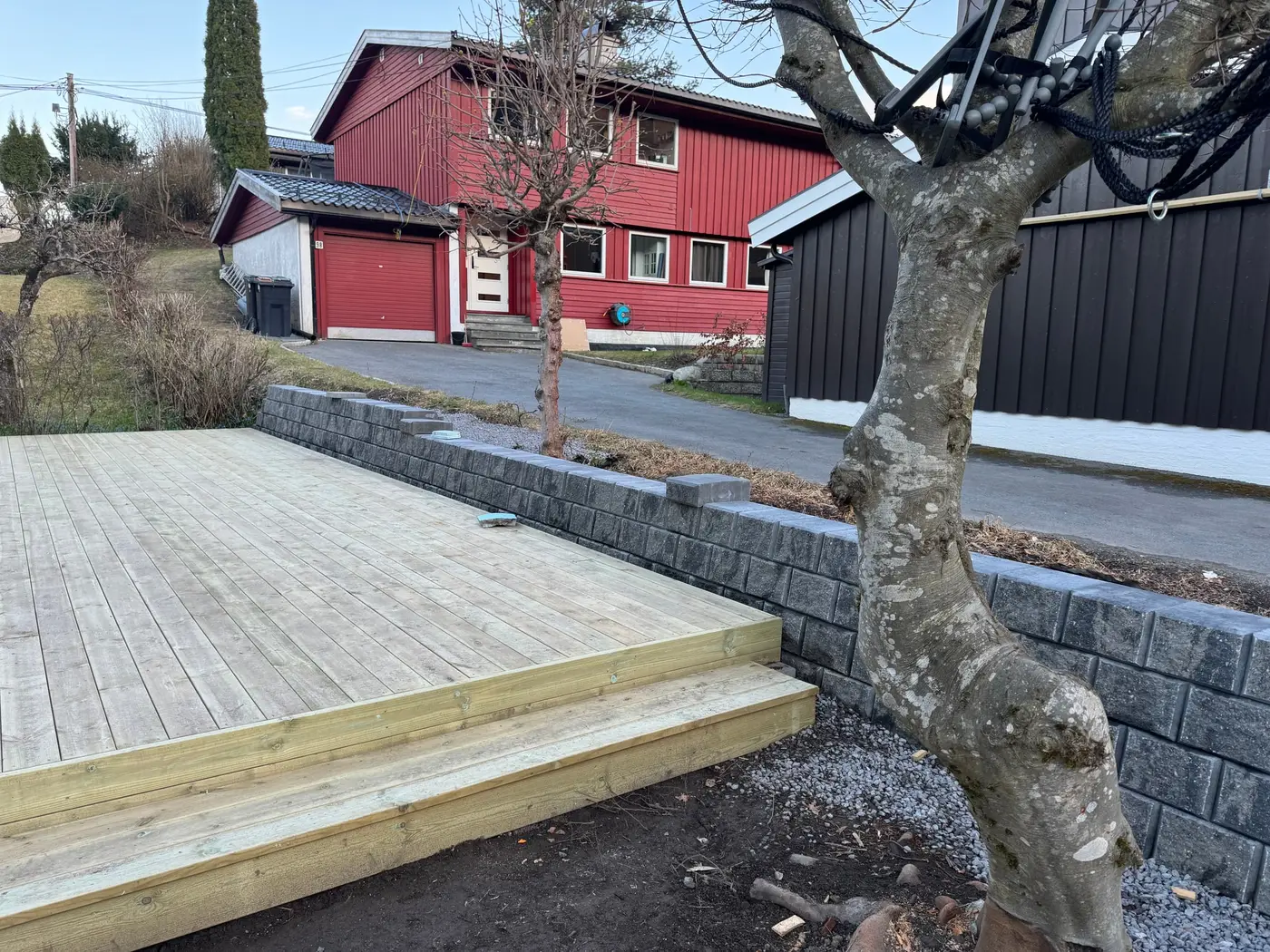 Platting med to trinn ved siden av grå betongstøttemur
