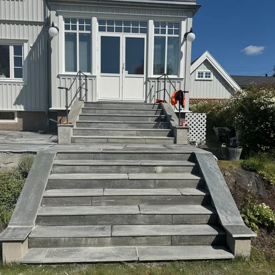 Utetrapp i skifer opp til inngangspartiet på hvit villa
