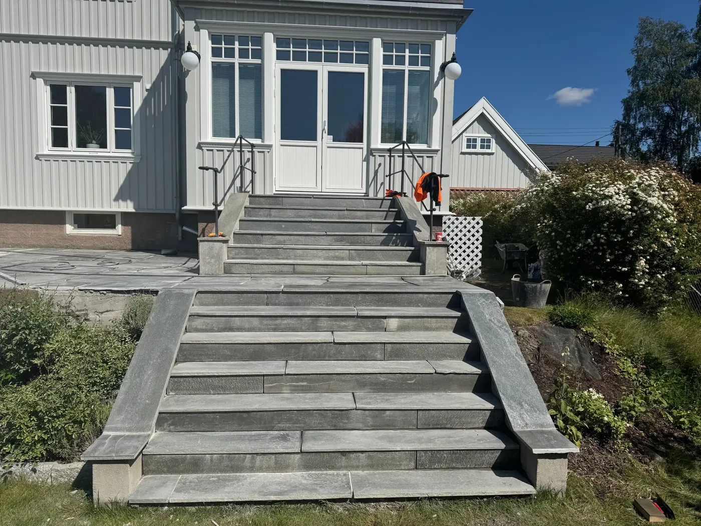 Utetrapp i skifer opp til inngangspartiet på hvit villa