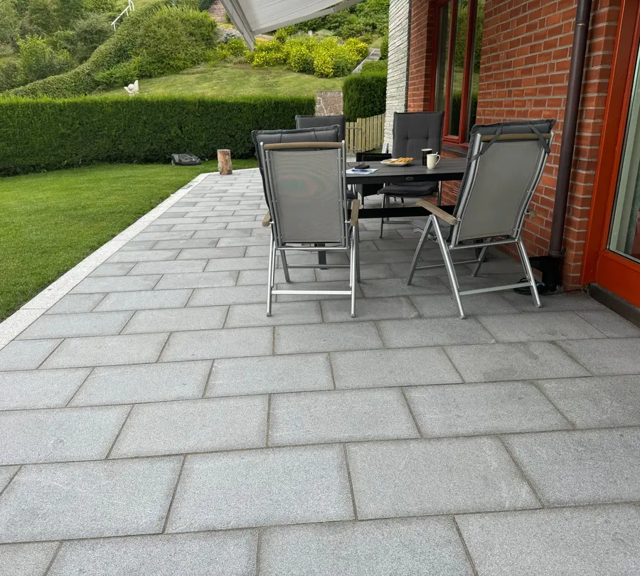 Ferdig terrasse i granittheller med spisegruppe, bygget av Perfekt Hage
