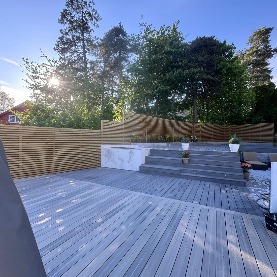 Ferdig terrasse i grå kompositt med trappetrinn, spotter og spilegjerde