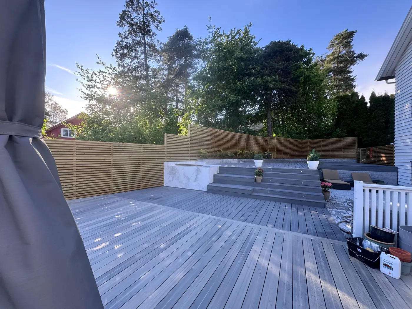 Ferdig terrasse i grå kompositt med trapp, spotter og spilegjerde